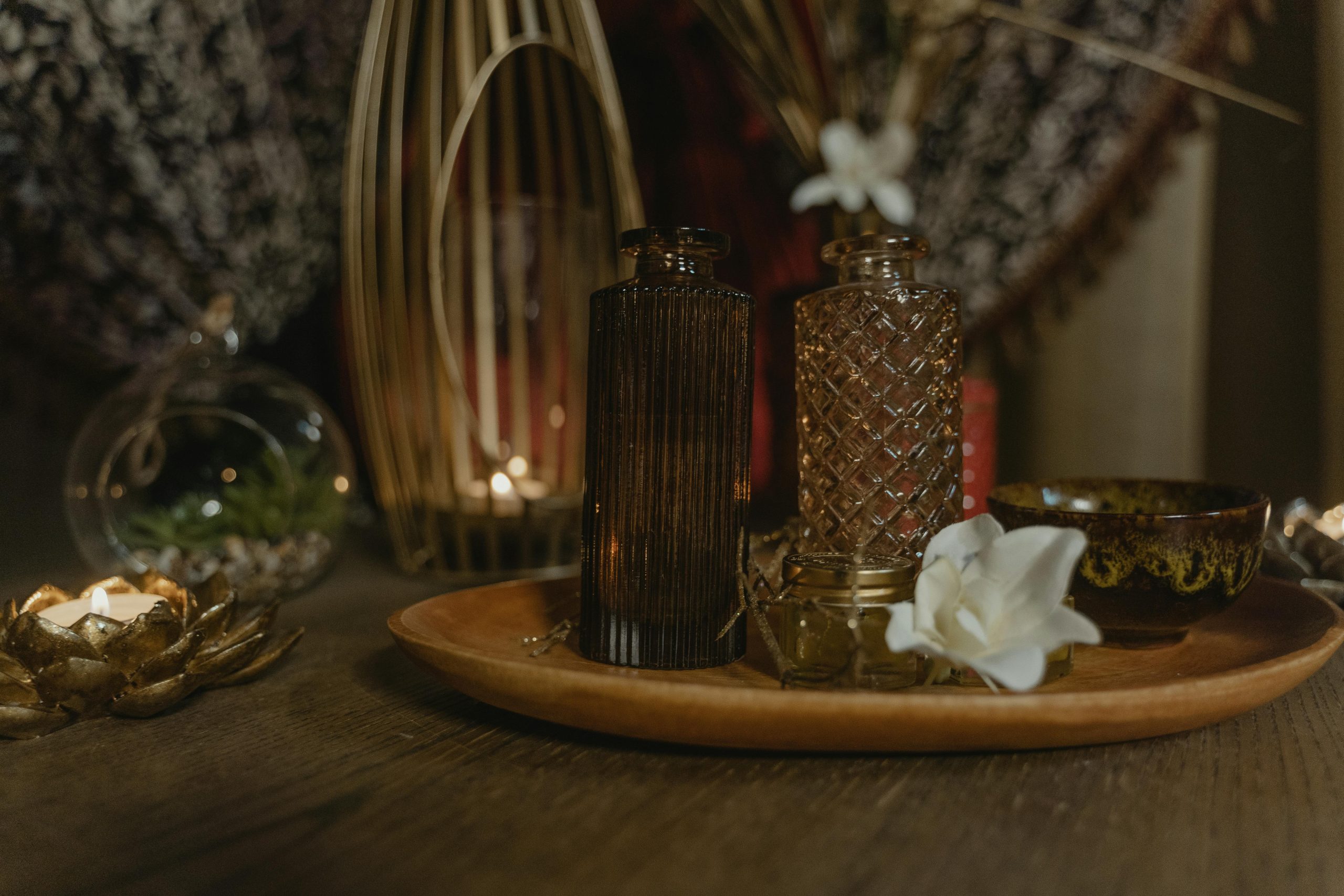 Serene spa setting with elegant candlelight and decorative vases on a wooden tray.